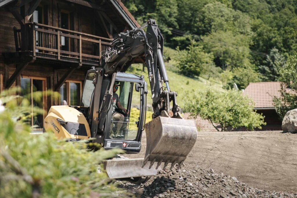 Artisan entrain de conduire un engin de TP sur un chantier de terrassement